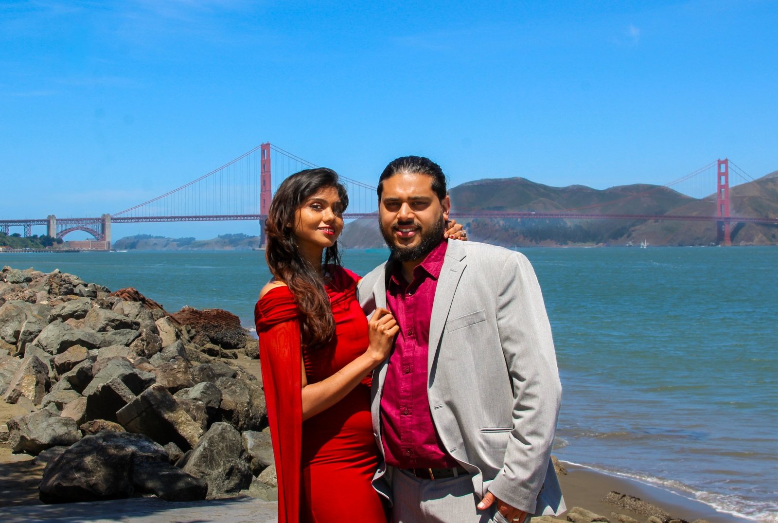 Prunella and Johnetan standing by the water with the Golden Gate Bridge stretching behind them