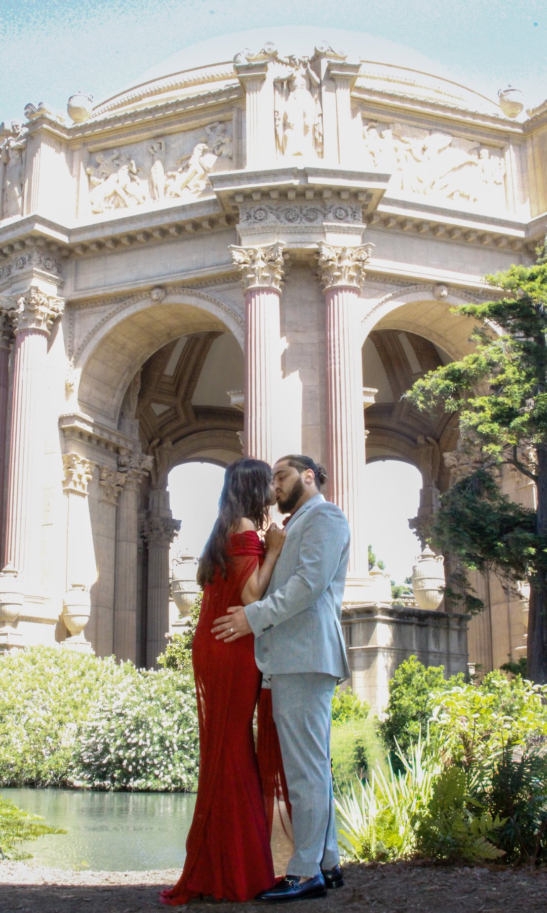 Prunella and Johnetan sharing a kiss beneath the Palace of Fine Arts dome